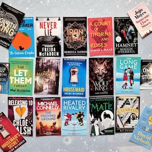 May include: A selection of books with diverse covers, including titles such as "Fourth Wing," "Never Lie," and "A Court of Thorns and Roses." The books are arranged on a light surface, showcasing a variety of genres and authors. The image includes both hardback and paperback books.