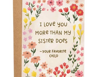 May include: Greeting card with a floral border of pink, red, and yellow flowers. The card reads "I love you more than my sister does - your favorite child" in black text. The card is inside a brown envelope.