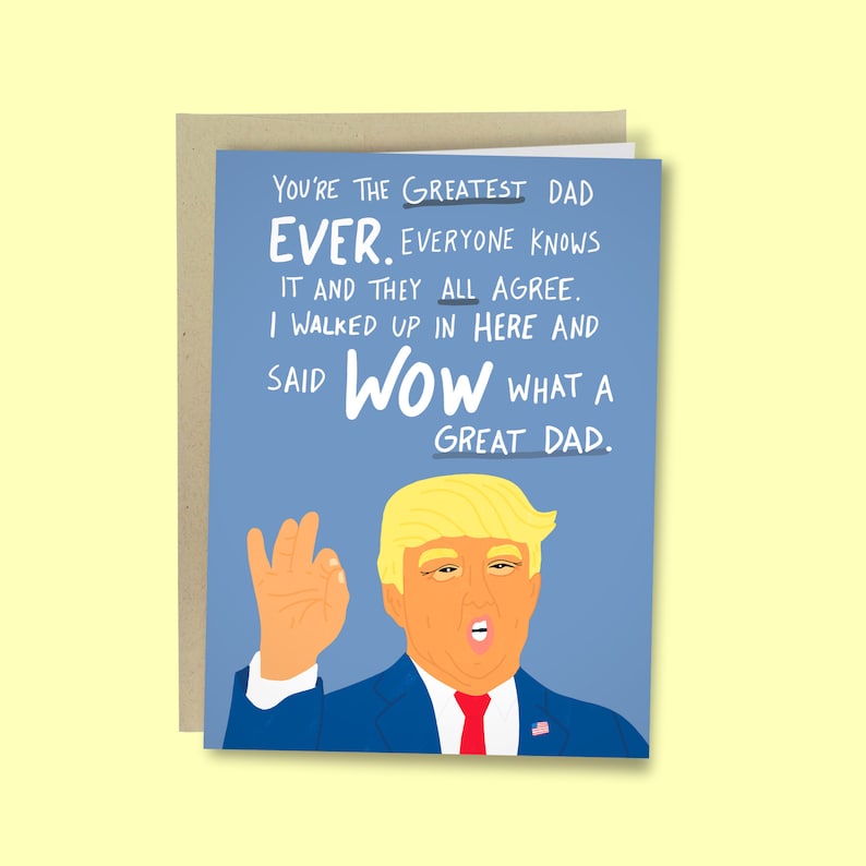 Puede incluir: Una tarjeta de felicitaci&oacute;n con fondo azul y el texto "YOU'RE THE GREATEST DAD EVER." Se muestra una ilustraci&oacute;n de un hombre con cabello rubio y un traje azul. La tarjeta est&aacute; dentro de un sobre marr&oacute;n.