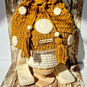 May include: A crocheted mustard yellow bucket bag with white polka dots and tassels. The bag has a wooden tag that says "Live well lotus".