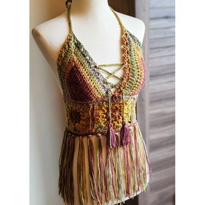 May include: A crocheted halter top with a multicolored, geometric pattern and fringe. The top has a lace-up front and a wooden button with a peace sign.