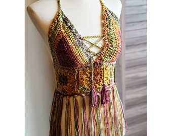 May include: A crocheted halter top with a multicoloured, geometric pattern and fringe. The top has a lace-up front and a wooden button with a peace sign.