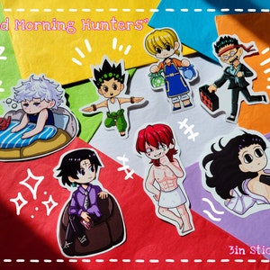 May include: A collection of 3-inch stickers featuring anime-style illustrations of characters. The stickers showcase various characters in different poses and outfits, with the text "Good Morning Hunters" and "3in Stickers".
