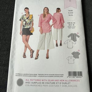 May include: A Burda Style sewing pattern package featuring illustrations of women's blouses. The package includes the text "BLUSE, BLOUSE, BLUSA" and size information. The package has a white background with images of the blouses.