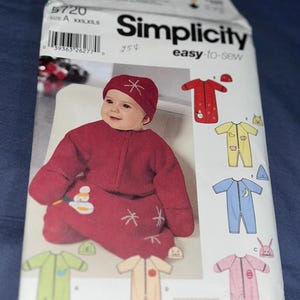 May include: A Simplicity 5720 sewing pattern envelope for infant sleepwear. The front features a photograph of a baby wearing a dark red fleece sleep sack and matching beanie with white snowflake embroidery. Illustrations show variations in red, yellow, blue, green, beige, and pink.