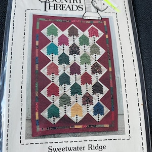 May include: A quilting pattern from Country Threads titled "Sweetwater Ridge" #177. The pattern features a quilt design with a red background and a variety of colorful trees.