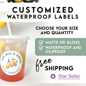 May include: A clear plastic cup filled with pink and yellow liquid, with a white lid and straw. The cup has a round label that reads "The Bee's Knees Fresh Lemonade" with a lemon illustration. Text above says "Customized Waterproof Labels".