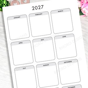 May include: A white 2027 yearly calendar sheet featuring twelve rectangular boxes with rounded corners, each labeled with a month name in black text. The layout is organized in a grid format with gray headers for each month and the text RHORO DESIGNS.
