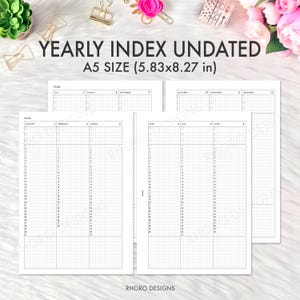 May include: White undated yearly index planner inserts, A5 size (14.8 x 21 cm), with grid and date columns. The text "YEARLY INDEX UNDATED" is at the top. The brand name "RHORO DESIGNS" is at the bottom.