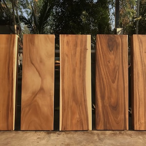 Może przedstawiać: Sześć drewnianych desek o różnych wzorach słojów i kolorach, ułożonych obok siebie. Deski są wszystkie tego samego rozmiaru i kształtu, a wszystkie wykonane są z jasnobrązowego drewna.