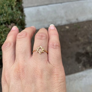 May include: A gold-toned ring with a star of David design.