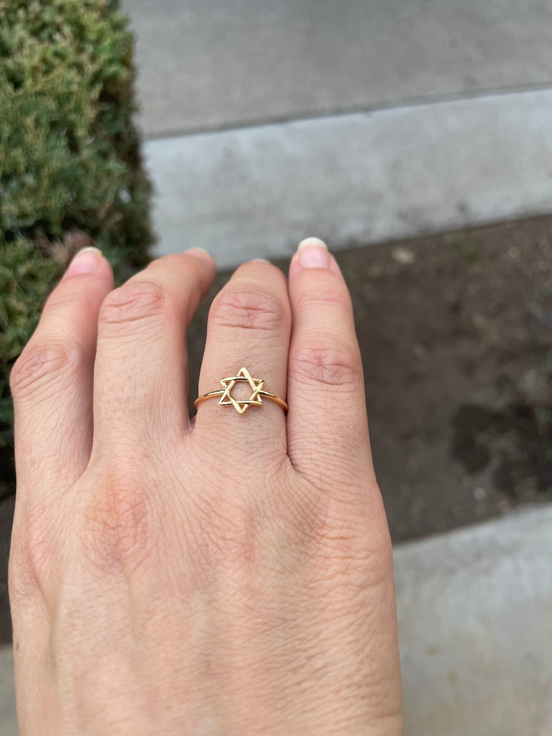 May include: A gold-toned ring with a star of David design.