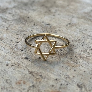 May include: A gold ring with a Star of David design.