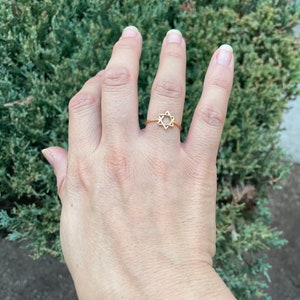 May include: A gold ring with a star of David design.