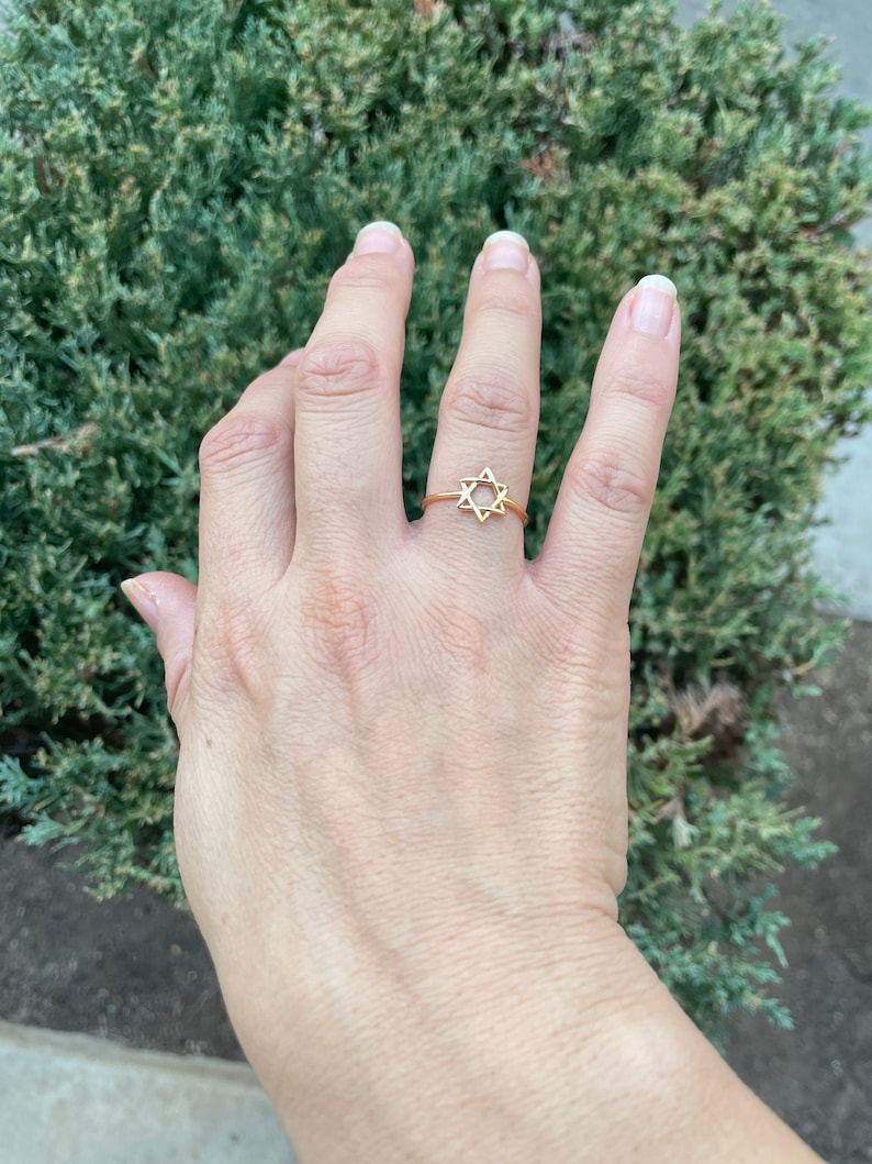 May include: A gold ring with a star of David design.