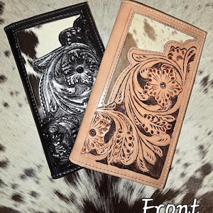 May include: Two rectangular checkbook covers featuring cowhide panels and intricate floral tooling. One cover is black with white cowhide, and the other is natural tan leather with white and brown cowhide. The word Front is printed below.