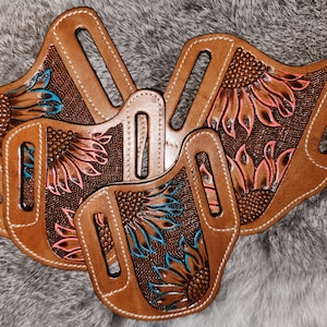 Puede incluir: Tres fundas de cuero marr&oacute;n con dise&ntilde;os de girasoles. Las fundas tienen bordados florales de color rosa y azul.