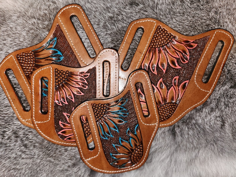 Puede incluir: Tres fundas de cuero marr&oacute;n con dise&ntilde;os de girasoles. Las fundas tienen bordados florales de color rosa y azul.