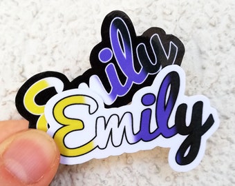 Op de afbeelding: Twee stickers met de naam "Emily" geschreven in een gestileerd lettertype. De bovenste sticker is zwart met paarse en gele accenten. De onderste sticker is wit met gele en paarse accenten.