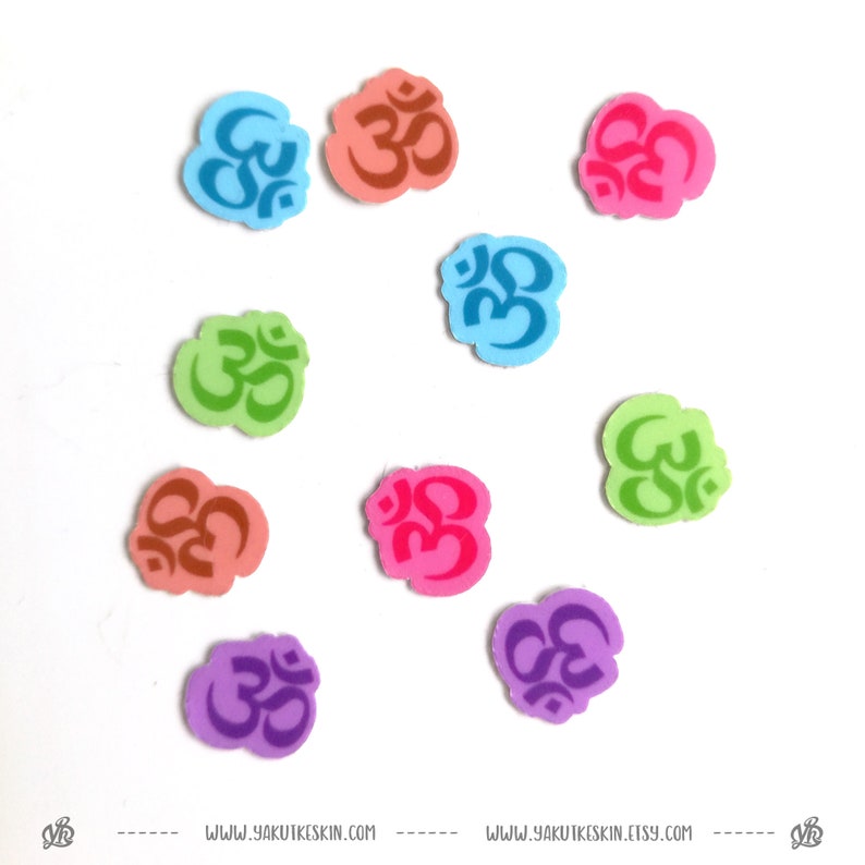 May include: Ten colorful Om symbol stickers in various colors including pink, blue, green, purple, and orange. The stickers are on a white background.