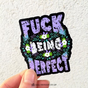 K&ouml;nnte beinhalten: Ein schwarzer und lilafarbener Aufkleber mit einem floralen Design und dem Text "F**k Being Perfect".