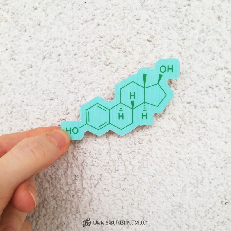 May include: A light blue sticker with a chemical formula for estradiol, a type of estrogen. The formula is printed in green text.
