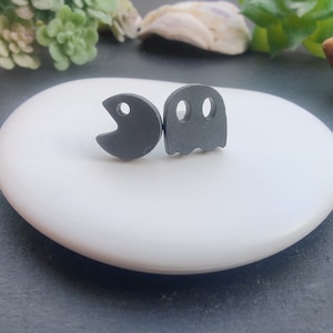 Könnte beinhalten: Ein Paar schwarze Ohrstecker mit einem Pac-Man- und einem Geistermotiv.