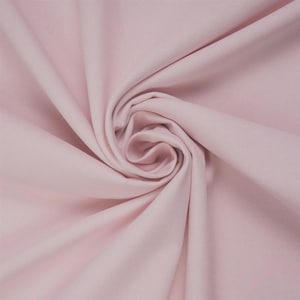 May include: A solid light pink fabric with a smooth, matte texture. The material is gathered in the centre, creating soft, radiating folds and deep shadows that highlight the consistent pastel colour and the fine, woven grain of the textile.