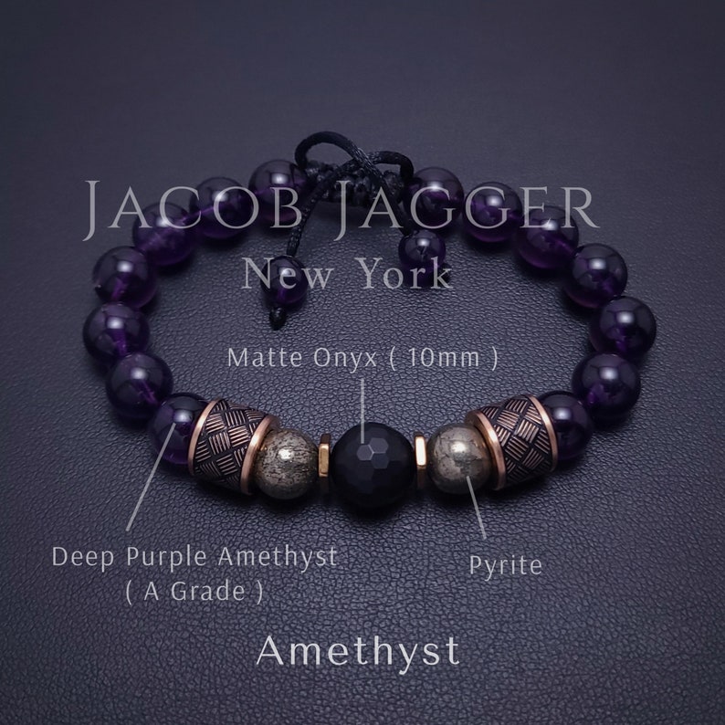 May include: A purple amethyst gemstone bracelet with a matte onyx bead, pyrite beads, and gold-toned metal accents. The bracelet is made by JACOB JAGGER New York.
