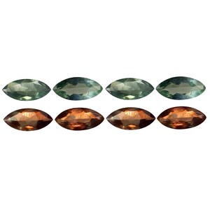 May include: Eight marquise-cut gemstones. The top row features four green-blue stones, while the bottom row displays four reddish-brown stones. Each stone has a smooth, polished surface and a pointed, oval shape.