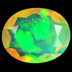 May include: Oval-shaped opal gemstone with a vibrant play of color. The gem features a mix of green, yellow, and orange hues, with a bright, luminous appearance. The facets create a star-like pattern within the stone, set against a black background.