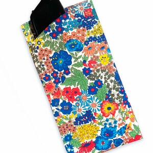 May include: A white fabric glasses case with a floral pattern in shades of red, blue, yellow, and green. The case has a black glasses cleaning cloth inside.