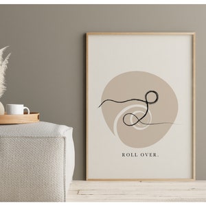 Puede incluir: Una impresi&oacute;n de arte minimalista con un dibujo de l&iacute;nea negra de un remolino sobre un fondo beige. El texto "ROLL OVER." est&aacute; impreso debajo del dibujo.