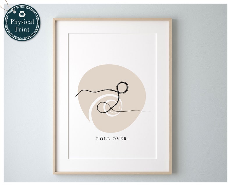 Puede incluir: Una impresi&oacute;n de arte minimalista con un dibujo de l&iacute;nea negra de un remolino en un c&iacute;rculo beige. El texto "ROLL OVER." est&aacute; impreso debajo del c&iacute;rculo.