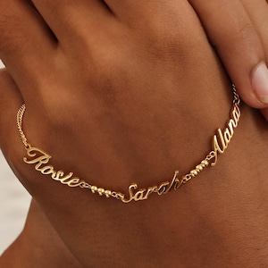 May include: Gold chain bracelet with three names, "Rosie", "Sarah", and "Alana", spelled out in cursive.