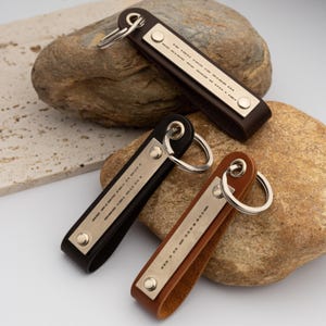 May include: Three leather keychains in brown, black, and tan, each with a silver metal plate featuring Morse code. The keychains have a loop for keys and are secured with metal rivets.