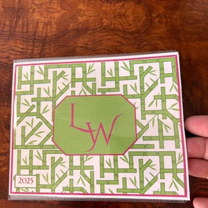 May include: A bamboo-themed notepad with a white background and green bamboo stalks. The notepad features a green and pink octagonal shape with the initials "LW" in pink. The year "2025" is printed in the lower left corner.