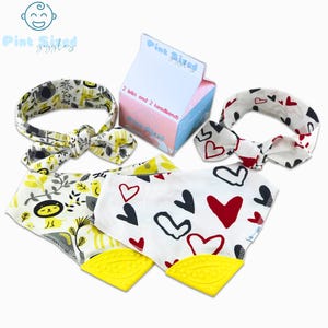 May include: A set of baby bibs and headbands. One bib and headband set features a yellow and gray animal print, while the other has a white background with red and black hearts. The box reads "2 bibs and 2 headbands."