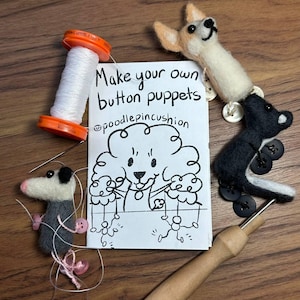 May include: A craft kit with the text "Make your own button puppets" and a drawing of a dog. The kit includes a spool of white thread, a needle tool, and felt animal puppets attached to buttons.