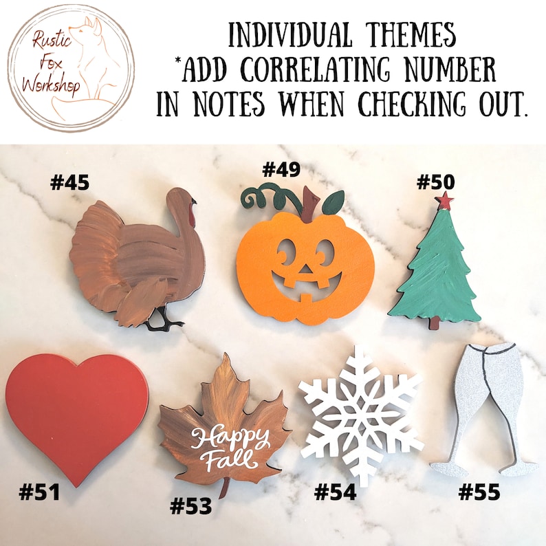 May include: Wooden cutouts in various shapes and colors, including a turkey, pumpkin, Christmas tree, heart, maple leaf with "Happy Fall" text, snowflake, and champagne glasses. Each cutout has a correlating number for ordering.