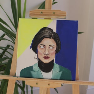 May include: A painting on canvas of a woman with dark hair and a green jacket. The background is a yellow, white, and blue color scheme.