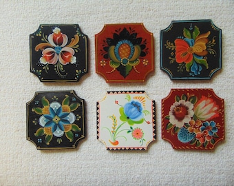 May include: Six square-shaped coasters with painted floral designs. The coasters are painted in various colors, including red, blue, green, yellow, and white. The designs are intricate and detailed, and the coasters are a beautiful addition to any home.