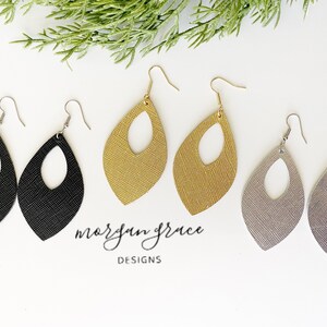 May include: Three pairs of dangle earrings with a teardrop shape and a cut-out oval in the center. The earrings are made of leather and come in black, gold, and silver.