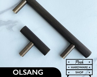 May include: Two black cabinet pulls with a ribbed texture. The larger pull is 5 inches long and the smaller pull is 3 inches long. Both pulls have a brushed brass finish.