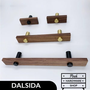May include: Four wooden cabinet pulls with gold and black knobs. The pulls are made of walnut wood and have a modern design.  The pulls are available in different sizes.