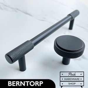 May include: Black cabinet hardware set featuring a long, textured bar handle and a round knob. The handle and knob have a matte black finish. The text "BERNTORP" and "Posh Hardware Shop" is visible in the image.