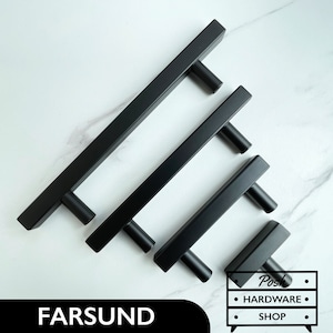 May include: Four black metal cabinet pulls of varying sizes. The pulls are rectangular with rounded edges and have a simple, modern design.