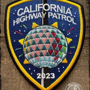 May include: A blue and yellow embroidered patch with the text "California Highway Patrol" and a disco ball design. The year 2023 is also embroidered on the patch.
