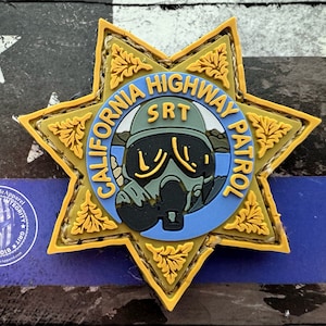 Op de afbeelding: Een gele stervormige patch met de woorden "California Highway Patrol SRT" in een blauwe cirkel. De patch heeft een afbeelding van een persoon met een gasmasker.