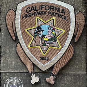 May include: A brown embroidered patch shaped like a turkey with the words "CALIFORNIA HIGHWAY PATROL" and a star with two figures inside. The year 2023 is printed below the star.
